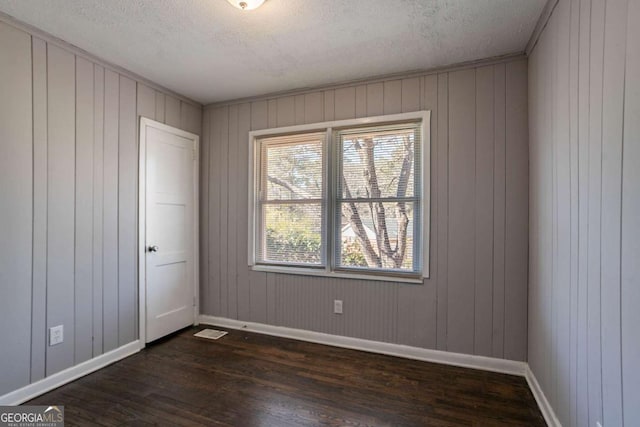 unfurnished room featuring dark hardwood / wood-style floors and a textured ceiling