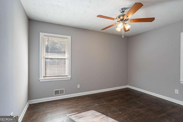 spare room featuring ceiling fan, dark hardwood / wood-style flooring, and a textured ceiling