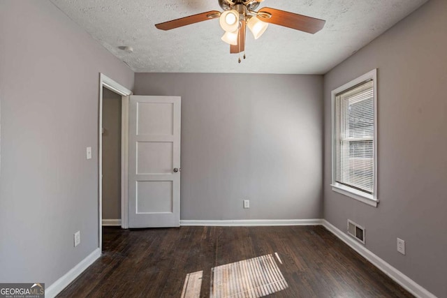 unfurnished room with a textured ceiling, ceiling fan, and dark wood-type flooring