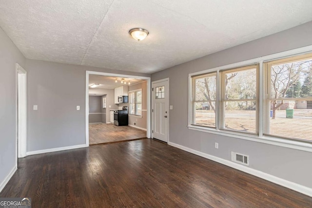 interior space featuring a textured ceiling and dark wood-type flooring