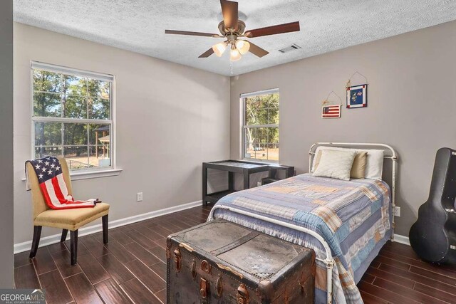 bedroom with ceiling fan and a textured ceiling