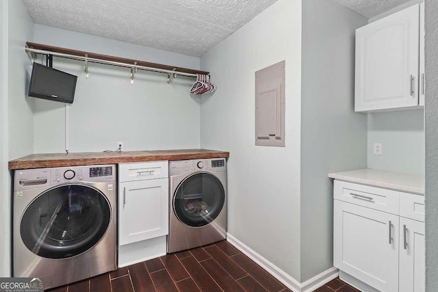 laundry area featuring cabinets, a textured ceiling, electric panel, and separate washer and dryer