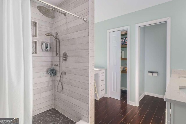 bathroom with vanity and a tile shower