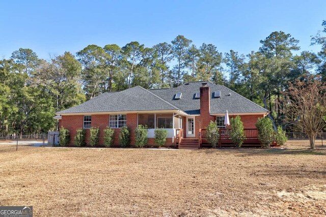 ranch-style home with a deck and a front lawn