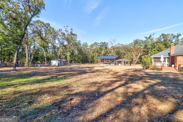 view of yard with a deck and a storage unit