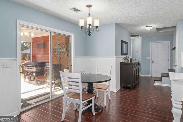 dining room with a chandelier and a textured ceiling