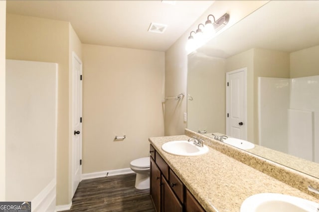 bathroom with vanity, toilet, and hardwood / wood-style floors