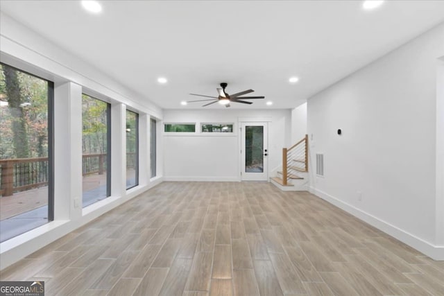 unfurnished living room with ceiling fan, light wood-type flooring, and plenty of natural light