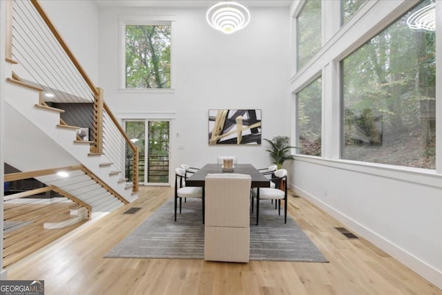 dining area featuring a high ceiling, hardwood / wood-style floors, and plenty of natural light