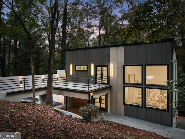 back house at dusk with a balcony