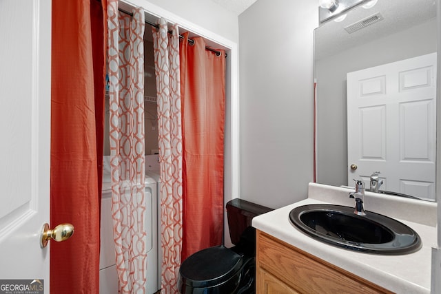 bathroom featuring vanity, toilet, and a textured ceiling