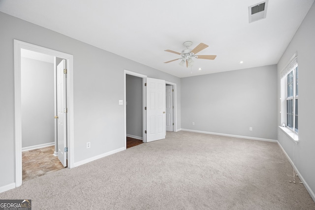 unfurnished bedroom featuring ceiling fan and light colored carpet