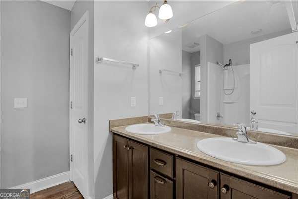 bathroom with a shower, hardwood / wood-style floors, and vanity