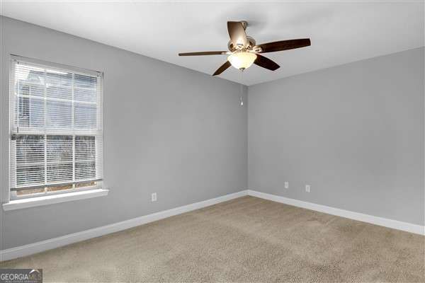 unfurnished room featuring light carpet, plenty of natural light, and ceiling fan