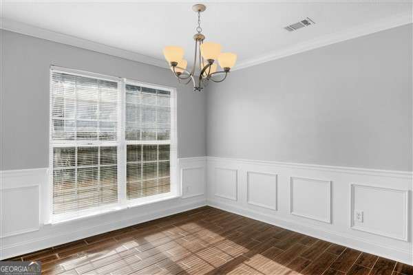 unfurnished dining area with ornamental molding and a chandelier