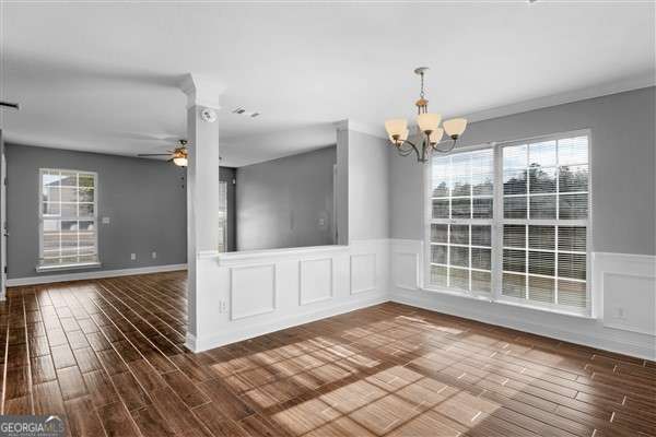 unfurnished dining area with ceiling fan with notable chandelier