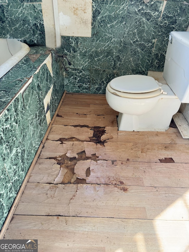 bathroom with toilet and wood finished floors