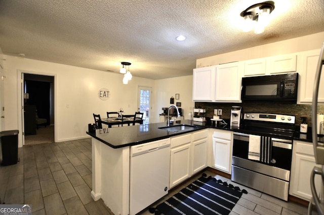 kitchen with white dishwasher, kitchen peninsula, sink, and stainless steel range with electric cooktop