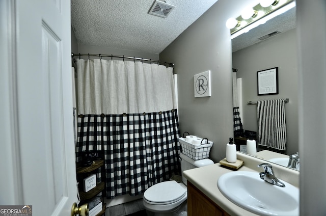 bathroom with vanity, a textured ceiling, and toilet