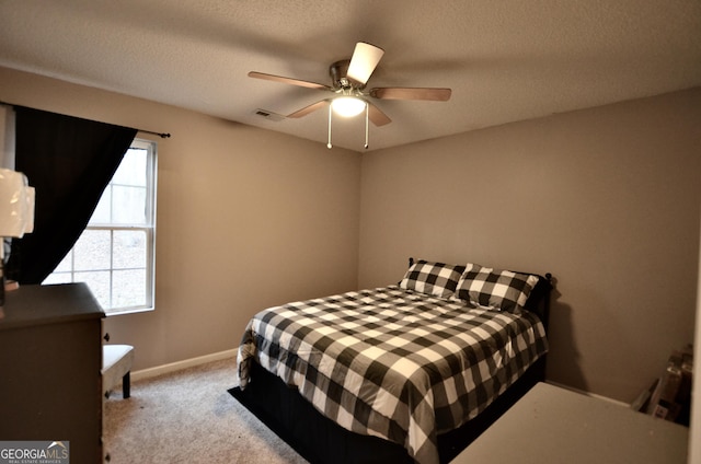 carpeted bedroom with a textured ceiling and ceiling fan