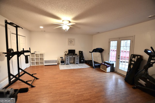 exercise room with french doors, a textured ceiling, hardwood / wood-style flooring, and ceiling fan