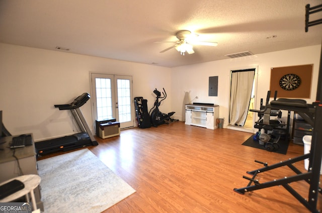 exercise area with hardwood / wood-style floors, electric panel, french doors, ceiling fan, and a textured ceiling