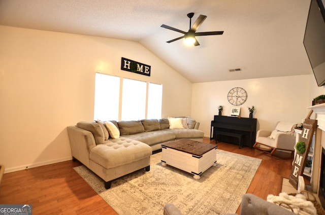 living room with ceiling fan, vaulted ceiling, and hardwood / wood-style flooring