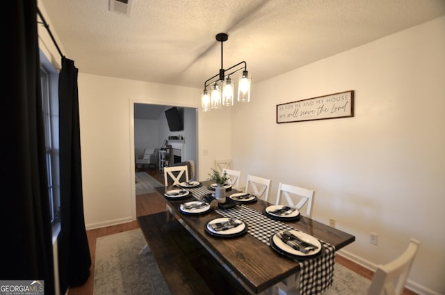 dining space featuring hardwood / wood-style flooring and a textured ceiling