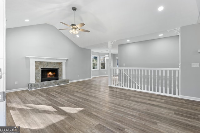 unfurnished living room with a premium fireplace, ceiling fan, vaulted ceiling, and hardwood / wood-style flooring