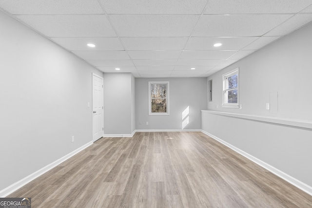 basement with a drop ceiling and light hardwood / wood-style floors