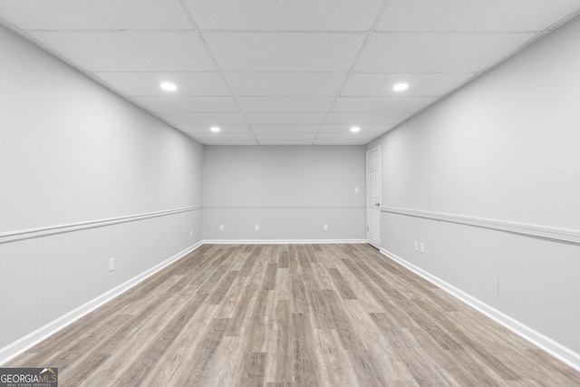 empty room with a paneled ceiling and light wood-type flooring