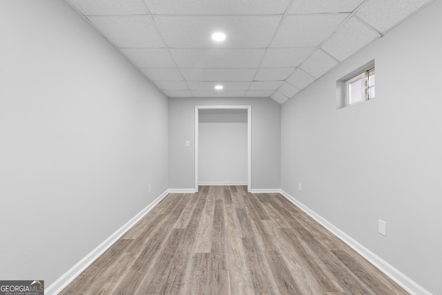 basement with light hardwood / wood-style flooring and a drop ceiling