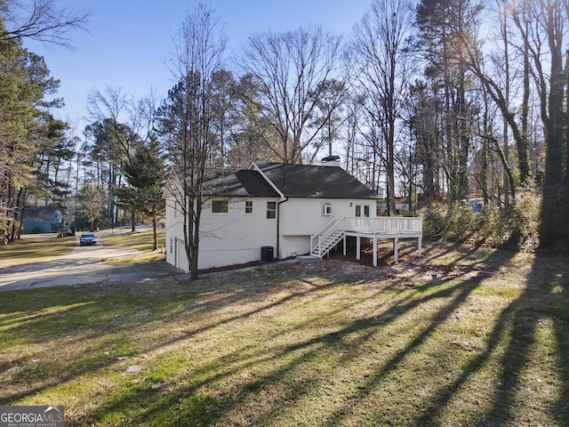 back of house featuring a yard, central AC unit, and a deck