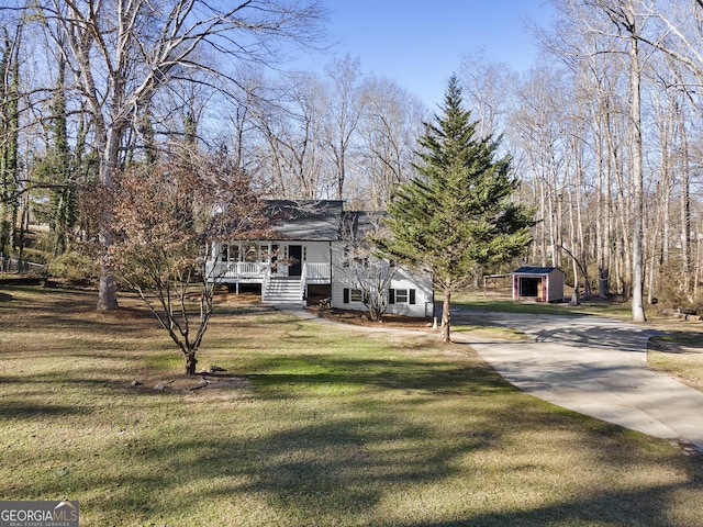 view of front facade with a front lawn and a storage shed