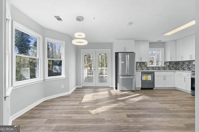 kitchen with white cabinets, appliances with stainless steel finishes, and tasteful backsplash