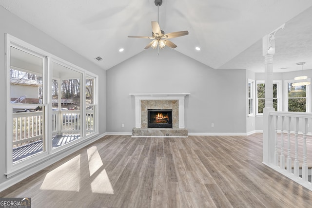 unfurnished living room with a tile fireplace, ceiling fan, vaulted ceiling, and hardwood / wood-style flooring