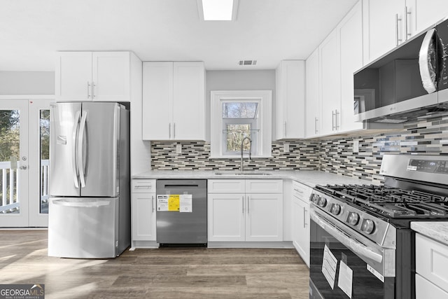 kitchen featuring backsplash, sink, white cabinets, and stainless steel appliances