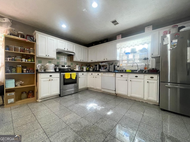 kitchen featuring tasteful backsplash, white cabinets, stainless steel appliances, and a textured ceiling