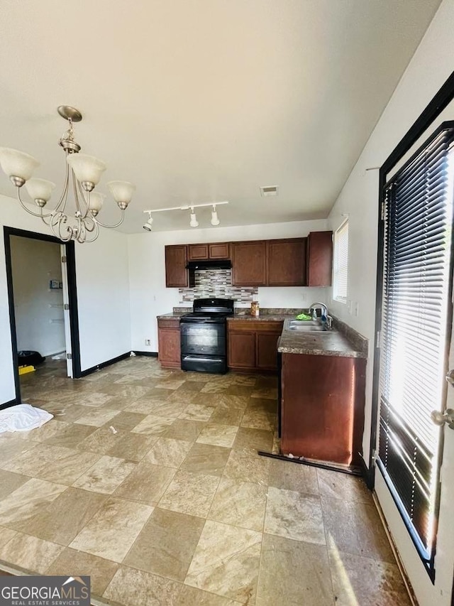 kitchen with black electric range oven, sink, hanging light fixtures, decorative backsplash, and a notable chandelier