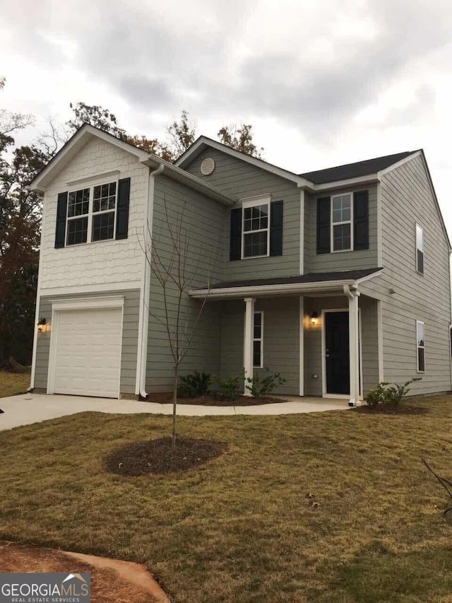 view of front property featuring a garage and a front yard