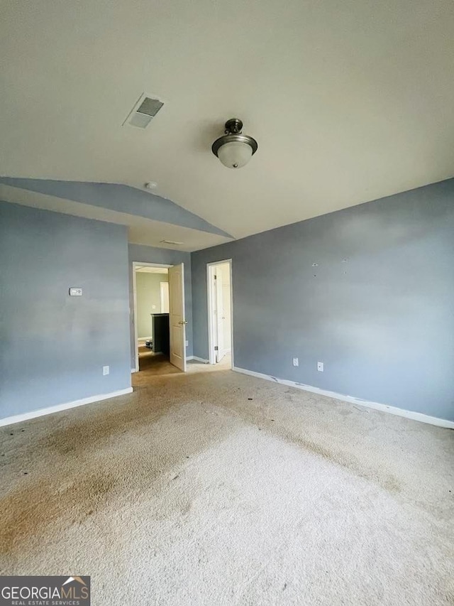 empty room featuring carpet floors and lofted ceiling