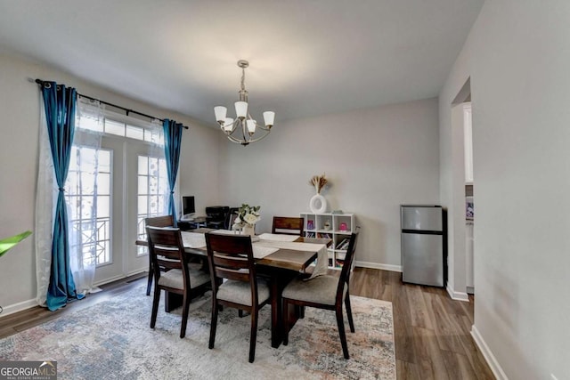 dining space featuring hardwood / wood-style floors and a notable chandelier