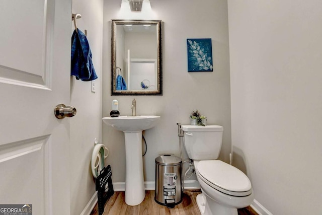 bathroom with sink, wood-type flooring, and toilet