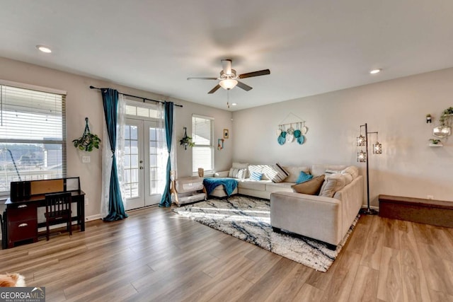 living room with a healthy amount of sunlight, light wood-type flooring, and french doors