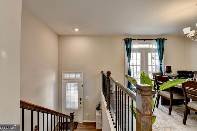 stairway featuring a chandelier