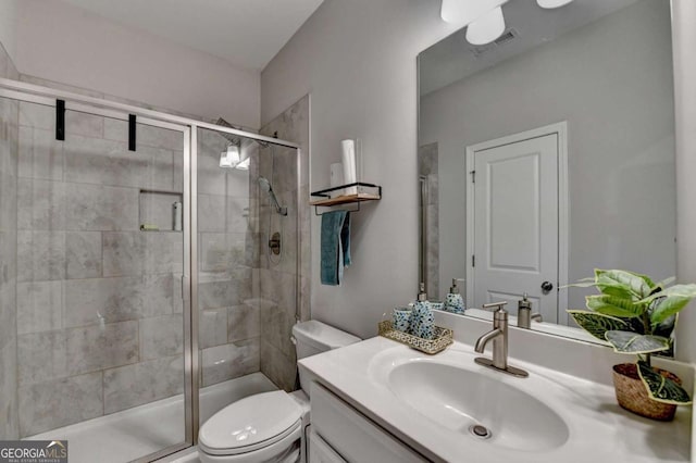 bathroom with vanity, an enclosed shower, and toilet