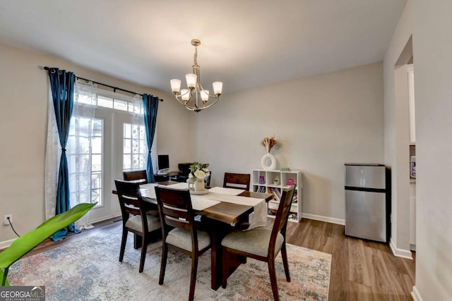 dining space featuring light hardwood / wood-style floors and a notable chandelier