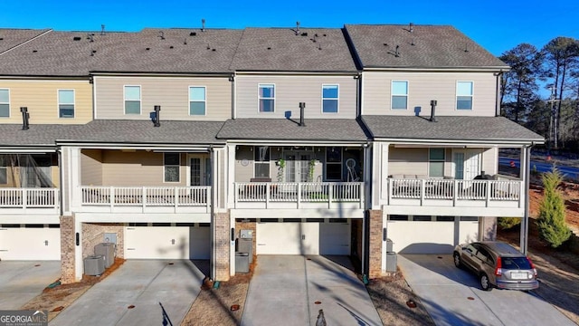 rear view of house with a garage, a balcony, and cooling unit