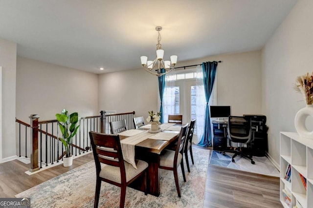 dining area featuring wood-type flooring and a notable chandelier