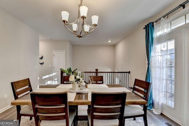 dining space with an inviting chandelier and dark wood-type flooring